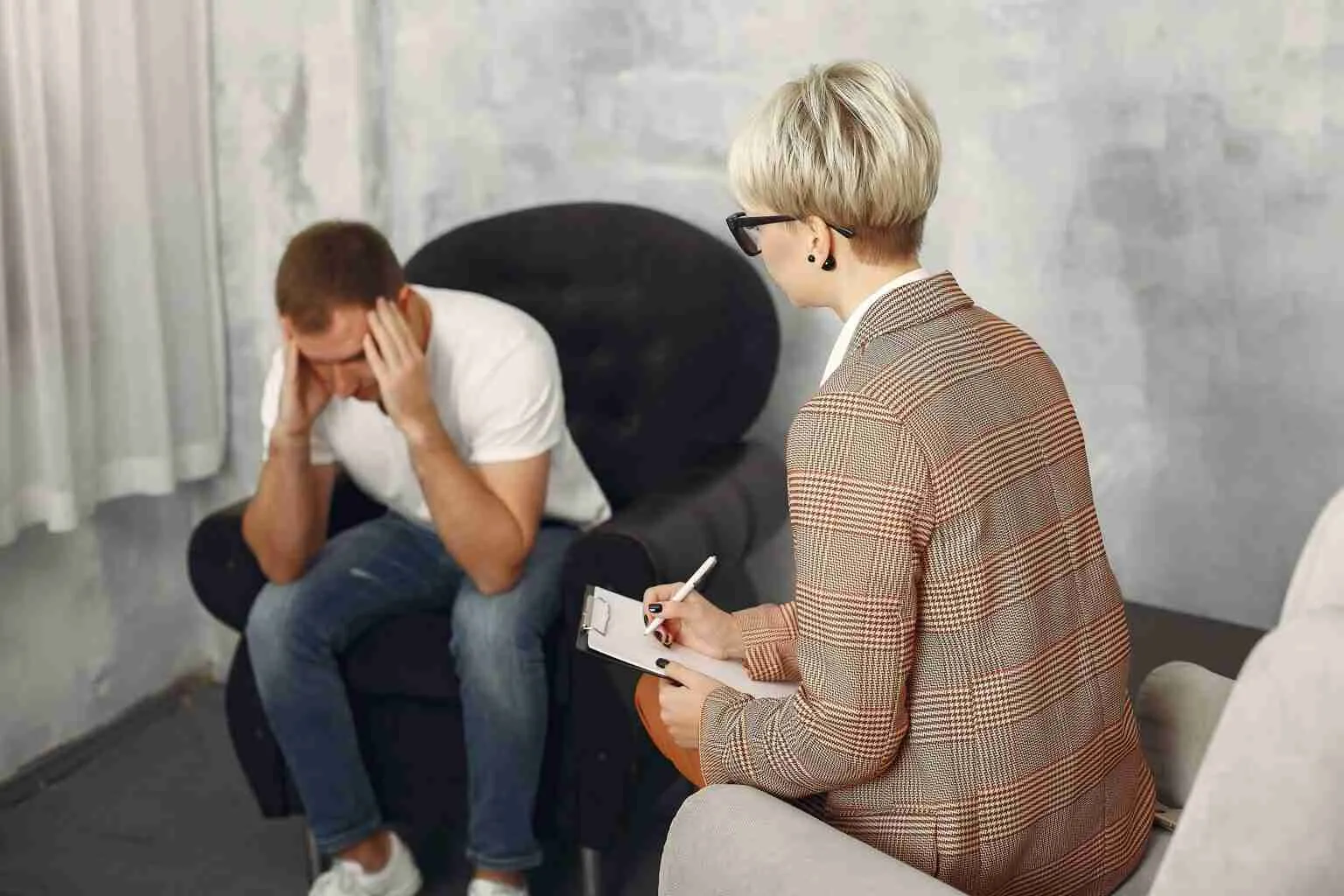man sitting psychologists office talking about problems